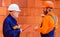 Two workers with helmets and builder uniform in construction site. Professional builders on work.