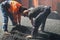 Two workers install sewer manhole