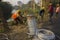 Two workers installing electric pole beside road and connecting with aluminum cable