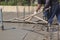 two workers leveling fresh concrete slab with a special wooden w