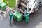 Two workers loading domestic waste in waste collection truck