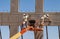 Two workers on man lift working on prefab wall using trowels