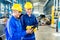 Two workers in production plant as team