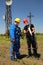 Two workers with protective equipment and Covid 19 masks install a telecommunications system