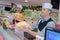 two workers slicing jamon and smiling at store