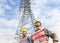 Two workers standing before electrical power tower