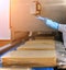 Two workers start making blocks of cheese in a factory