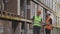 Two workers in a warehouse are discussing work. Engineers in a factory warehouse