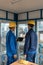 Two workers wearing hard hats while using a tablet PC