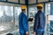 Two workers wearing hard hats while using a tablet PC