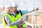 Two workers working outside with a tablet on a construction site