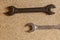 Two wrenches lie on a wooden surface, repair the house. pair of hand tools parallel horizontal