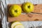 Two yellow apple lying on a wooden table