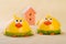 two yellow chicken cockerel on a light background near a wooden house