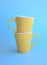 Two yellow cups on blue