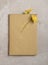 Two Yellow Daisy like flowers and old book and aged parchment . One flower being used as a book mark