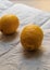 Two yellow peeled lemons lie on crumpled white paper