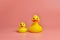 Two yellow rubber ducks toys, copy space. Cute funny bath toys, minimal kidult concept. Pink background