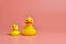 Two yellow rubber ducks toys, copy space. Cute funny bath toys, minimal kidult concept. Pink background