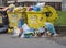 Two yellow rubbish container for plastic garbadge overloaded wit