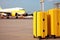 Two yellow suitcases on the background of an airplane at the airport. Generative ai