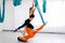 Two yogi women makes tandem yoga pose using blue hammock for aerial fly yoga. Concept wellness yoga, group training.