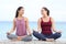 Two yogis talking doing yoga on the beach