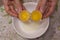 Two yolks in one egg. 2 in 1. Women`s hands open a unique egg with two yolks. The process of opening eggs for making cake,