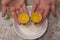 Two yolks in one egg. 2 in 1. Women`s hands open a unique egg with two yolks. The process of opening eggs for making cake,
