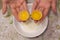 Two yolks in one egg. 2 in 1. Women`s hands open a unique egg with two yolks. The process of opening eggs for making cake,