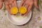 Two yolks in one egg. 2 in 1. Women`s hands open a unique egg with two yolks. The process of opening eggs for making cake,