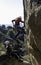 two young adults working together to climb a granite wall. Rock climbing. Extreme sports