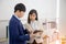 Two young Asian businessmen stand meeting in the office in the hand of the tablet