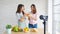 Two young asian women food bloggers talking while recording video with happy moment, vlog concept, people and technology