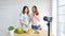 Two young asian women food bloggers talking while recording video with happy moment, vlog concept, people and technology