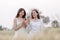 Two young asian women friends take walking relax and drink coffee cup in her hand at barley field agriculture demonstration plot