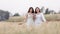 Two young asian women friends take walking relax and drink coffee cup in her hand at barley field agriculture demonstration plot