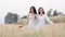 Two young asian women friends take walking relax and drink coffee cup in her hand at barley field agriculture demonstration plot