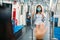 Two young asian women friends wearing protective mask meet in a subway train with bare hands. Instead of greeting with a hug or