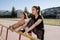 Two young athletic women in black tracksuits train at the stadium.. Stadium on background