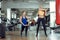 Two young athletic women train together in gym