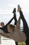 Two young attractive women doing acrobatics with cityscape on background