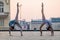 Two young ballerinas dancing in pointe shoes in city against the backdrop of sunset sky