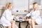 Two young beautiful girls in spa salon. blonde women are cute talking and drinking tea and coffee