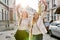 Two young beautiful happy women university students walking along city street