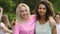 Two young beautiful multiracial women hugging and smiling to camera, friendship