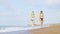 Two young beautiful sexy women in bikinis walk along the sandy beach, holding hands. Love and friendship. Summer, sea