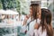 Two young beautiful women enjoy shopping while looking shop windows together