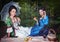 Two young beautiful women in medieval dresses having picnic