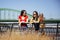 Two young best female friends standing by the old bridge